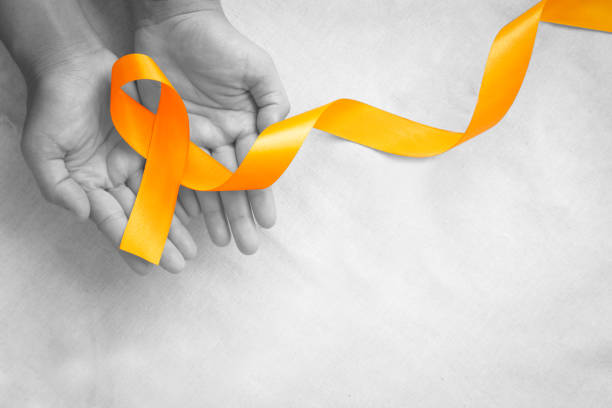 Hands holding orange color ribbon on white fabric with copy space. Kidney Cancer Awareness, Leukemia disease, Skin cancer awareness, World Cancer Day. Healthcare or hospital and insurance concept. cinta de color naranja en tejido blanco con espacio de copia. concienciación sobre el cáncer de riñón, enfermedad de la leucemia, concienciación sobre el cáncer de piel, día mundial contra el cáncer. concepto de salud o hospital y seguro.