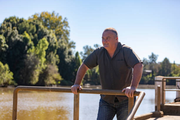 istock Happy Middle Aged Man Smiling by a River 1318783311
