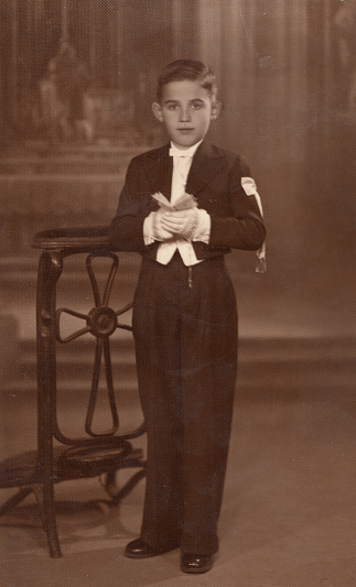 Vintage image from the 30s, studio shot of a little boy on the day of his first communion
