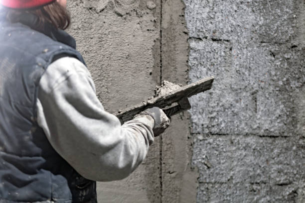 istock Real construction worker working on a wall inside the new house. 1318786759