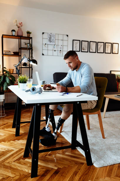 istock Amputee man using credit card for online purchase from home office 1318788946