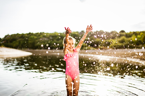 Beautiful girl having fun on a river during hot summer day.