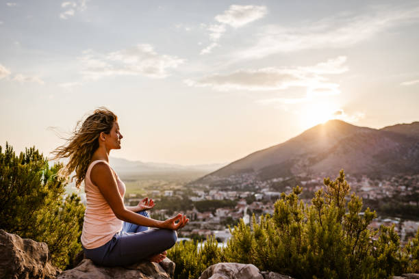 istock Young woman preforms yoga in mountains at sunset 1318792773
