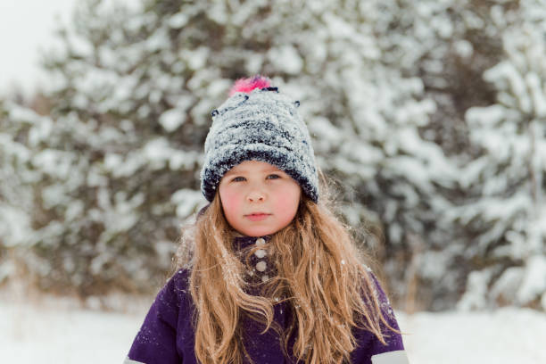 istock Girl in snowy hat outdoors winter trees background 1318792837