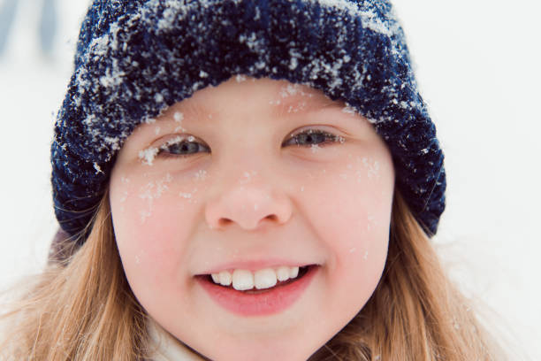 istock Close up kid face with snowflakes 1318792879