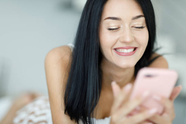 istock Happy vivacious young woman reading a text message on her mobile 1318798126