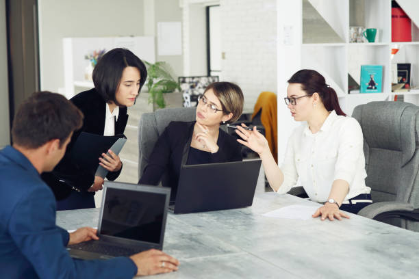 istock Three young successful business women in the office working together on a project 1318799566