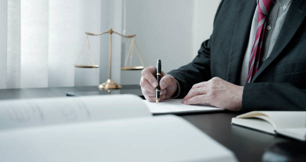 istock The lawyer was holding a pen to write legal documents on a table with 1318799580