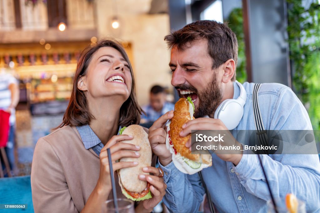 Couple have breakfast together Couple in restaurant eat sandwiches and have fun together. Happiness, people,enjoyment and lifestyle concept. Sandwich Stock Photo