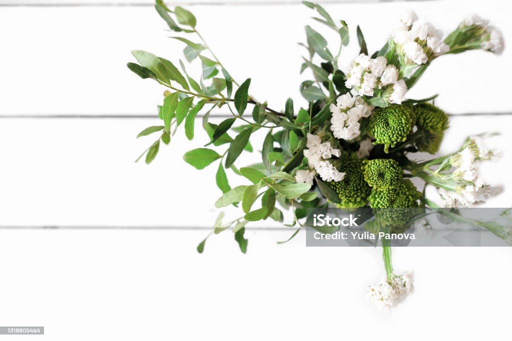 beyaz ahşap bir masada yeşil çiçekler buketi. üst görünüm. taze yaz çiçekleri ve kopya alanı ile yapraklar. blogcu içeriği. günaydın veya selamlama konsepti, rustik düğün buketi. - Royalty-free Ahşap Stok görsel