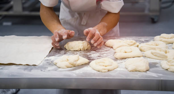 istock Chef  Baker prepares the dough on table, male hands knead the dough with flour. 1318806813
