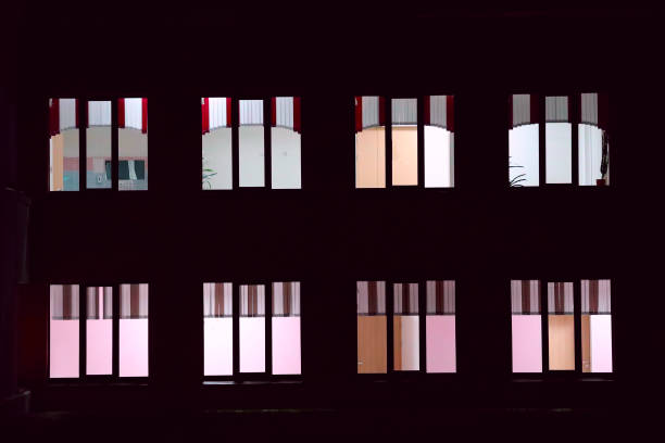 istock Windows glow in an apartment building at night 1318807552