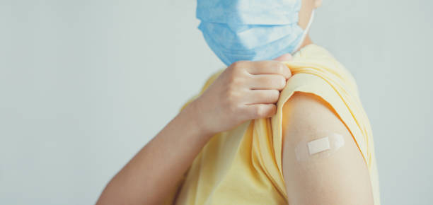 istock Human wearing face mask and showing his vaccinated arm. vaccination, recommended inoculation concept. 1318808266