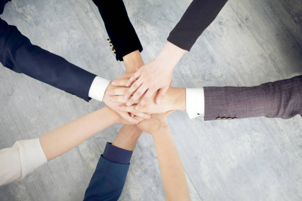 istock Unity and teamwork concept of young business people folding their hands together 1318808837