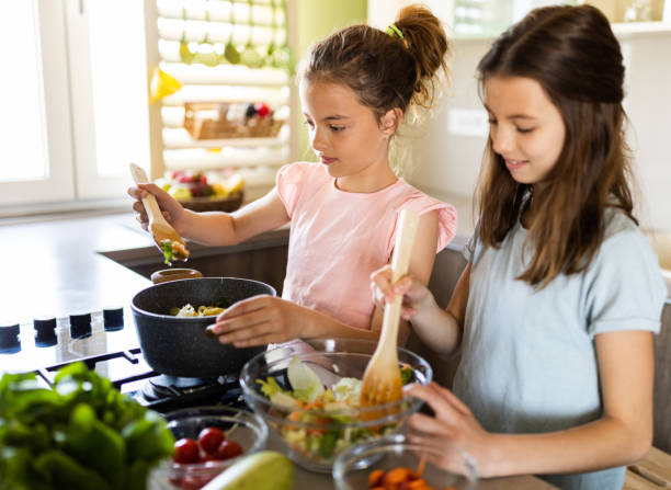 istock Girls cooking lunch in the kitchen 1318809047