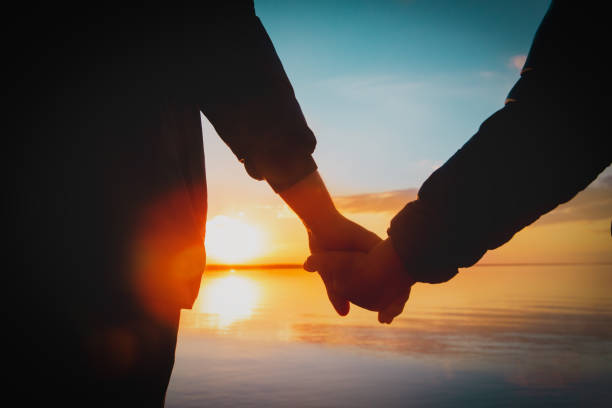 istock father and son holding hands at sunset nature 1318810993