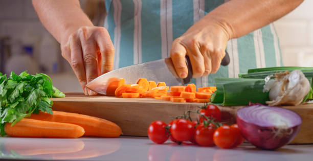 istock Woman chopping carrot on chopping board 1318814445