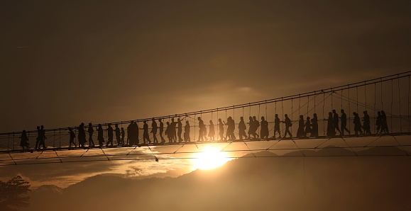 Nepali people cross a suspension bridge to go for offering prayers at a temple on festival of Shrawan Somvar in Devghat, a holy pilgrimage destination in Chitwan, Nepal.