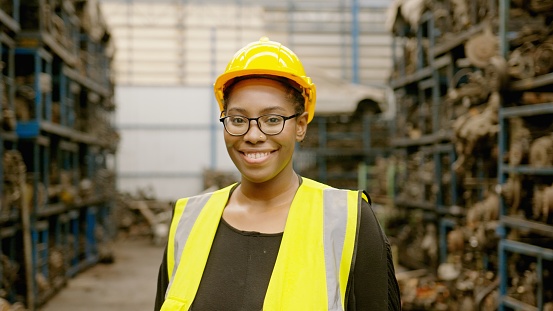 portrait of American African Engineering woman is working in heavy industrial plant Engine parts factory .