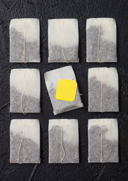 istock Teabags of black tea with yellow tag on black. 1318816286