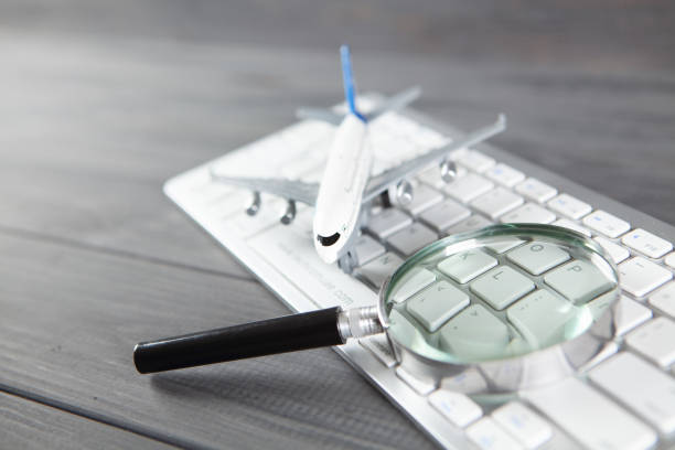 istock plane, magnifier and keyboard. online search for airline tickets 1318817232
