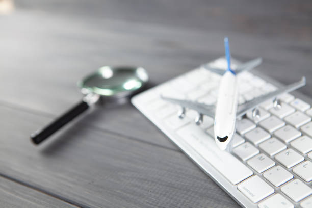 istock plane, magnifier and keyboard. online search for airline tickets 1318817251