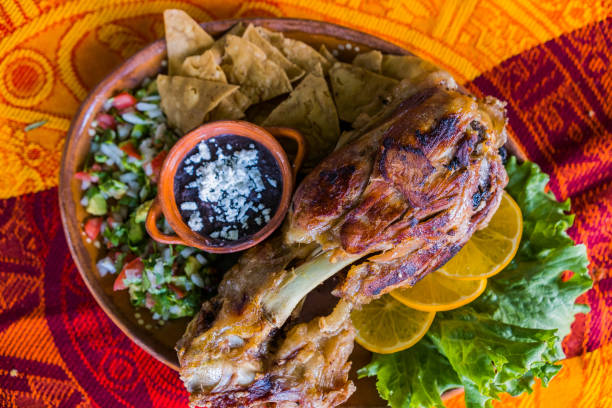 istock Roasted meat with vegetables and refried beans on colorful tablecloth 1318819881