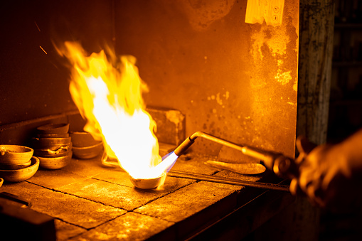 Melting gold on traditional way using burner in jewelry manufacture industry