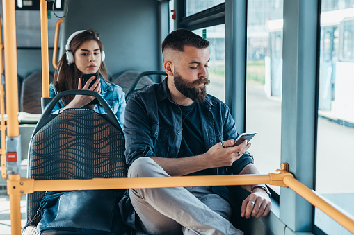 Man riding a bus and using a smartphone