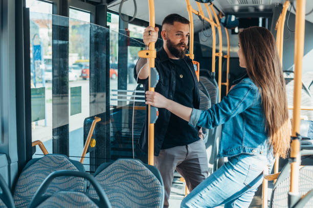 istock Couple standing in a moving bus and talking 1318822261