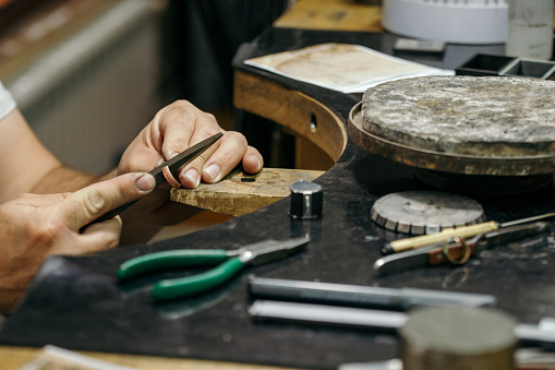 Jeweller repairing the diamond ring in jewelry manufacture workshop.