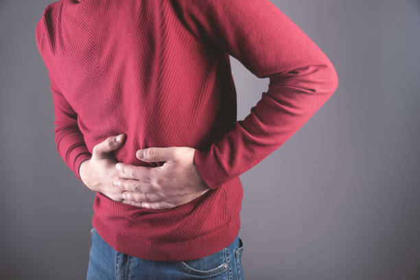 istock young guy holding his stomach in pain 1318823148