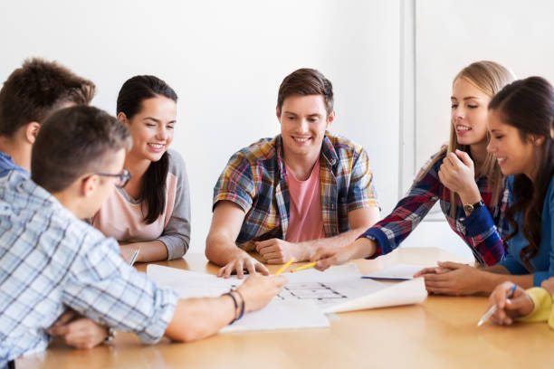 istock group of smiling students with blueprint 1318828214