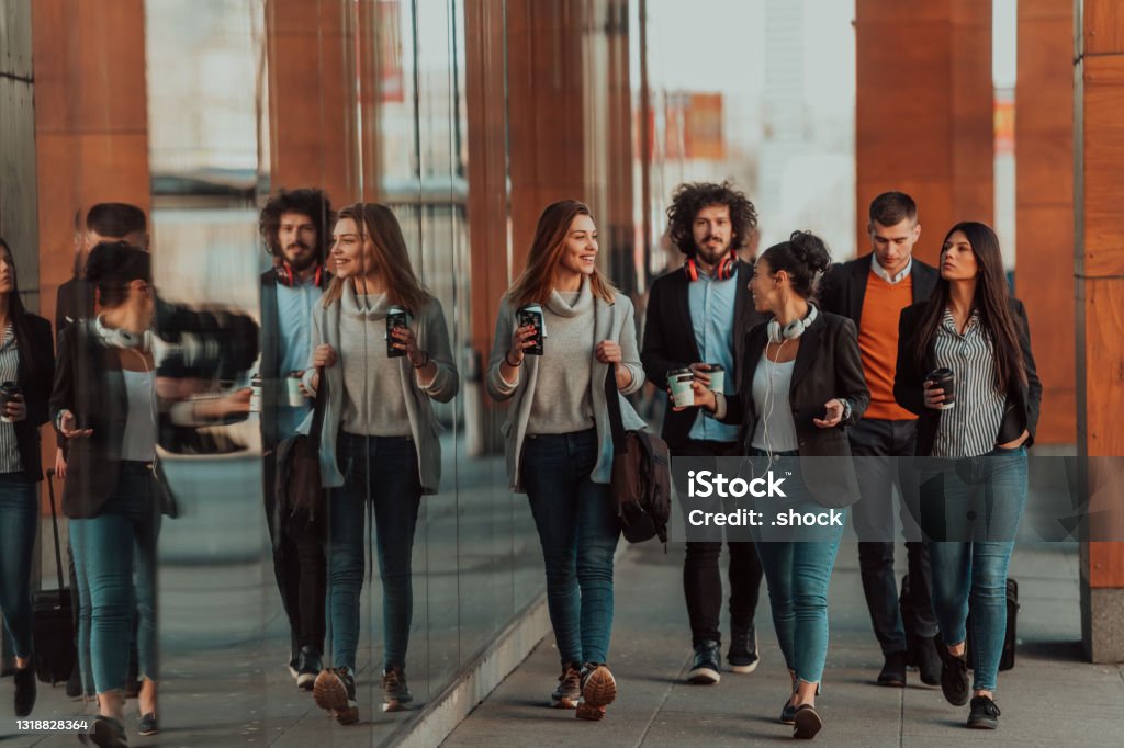 Business colleagues walking and talking on city streets Travelers business team of colleagues walking and talking on modern urban city streets. People on out of the office on break. High quality photo Walking Stock Photo