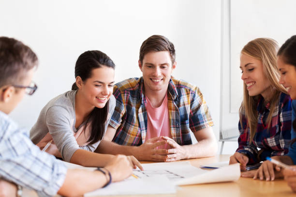 istock group of smiling students with blueprint 1318828397
