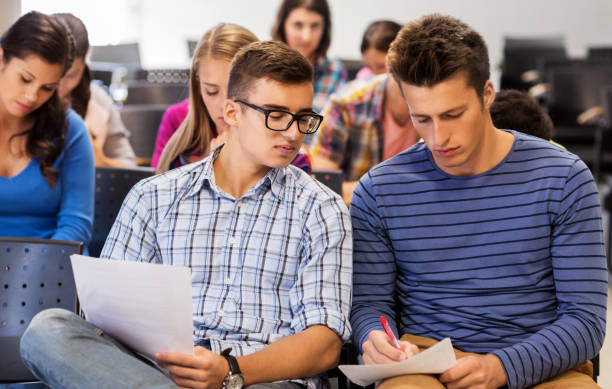 istock group of students with papers in lecture hall 1318828485