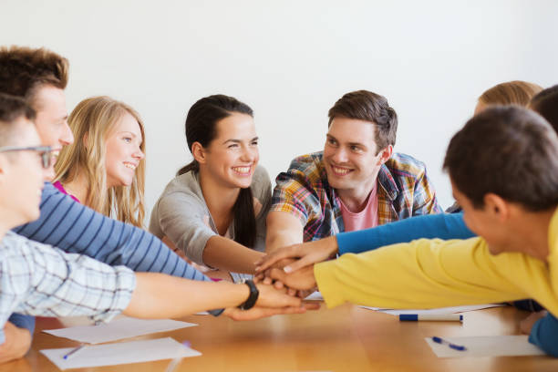 group of smiling students with hand on top