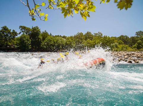 Group of people as they ride the rapids while white water rafting in the waves of a river. Koprulu Canyon Antalya, Turkey