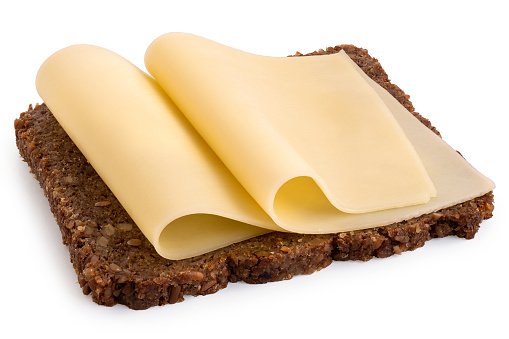 Two folded thin slices of yellow cheese on German health bread isolated on white.