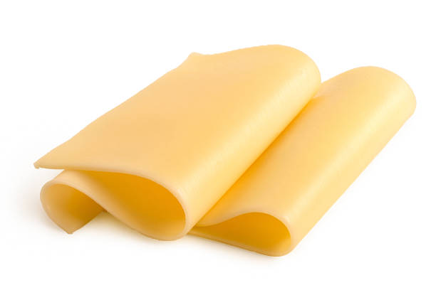 Sliced cheese Two folded thin slices of yellow cheese isolated on white. edam stock pictures, royalty-free photos & images