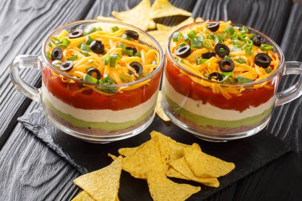 istock Delicious food appetizer Mexican seven-layer dip salad served with chips close-up. horizontal 1318832010