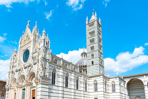 Sienna Cathedral with its tower and dome on a sunny day with blue sky and clouds.Tuscany, Italy.