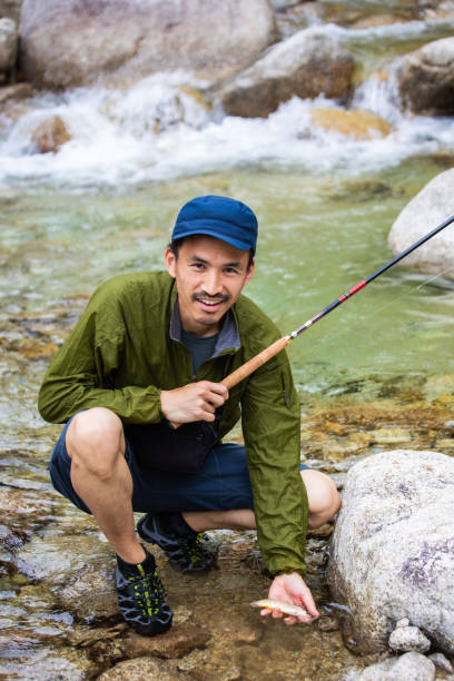 istock Tenkara fly fisherman caught a small freshwater fish 1318834465
