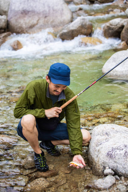 istock Tenkara fly fisherman caught a small freshwater fish 1318834486