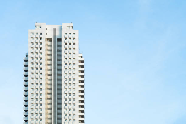 White modern skyscraper perfect symmetry with blue sky and copy space Front view of a white modern skyscraper perfect symmetry with blue sky and copy space. Architecture background concept highrise condominiums stock pictures, royalty-free photos & images