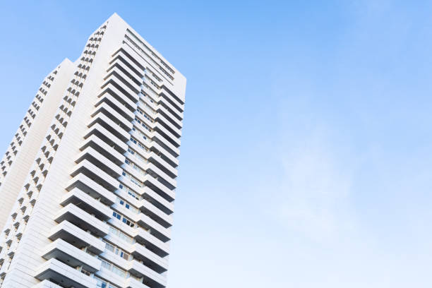 Low angle view of a modern white skyscraper with blue sky