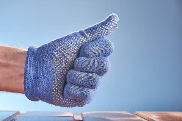 Worker sitting at table and wearing gloves before working with glass cutting