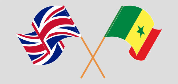 скрещенные и развевающиеся флаги великобритании и сенегала - england senegal stock illustrations