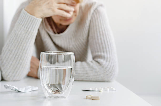 istock Senior woman suffering and taking pills 1318837494