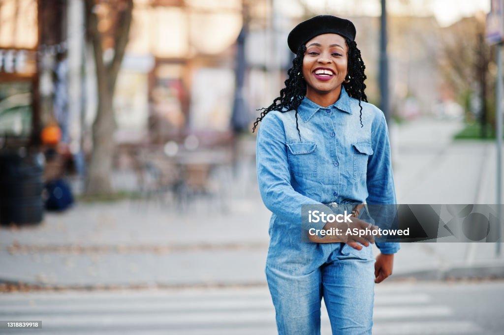 Stylish fashionable african american women Stylish fashionable african american women in jeans wear and black beret walking on pedestrian traffic. Nigeria Stock Photo